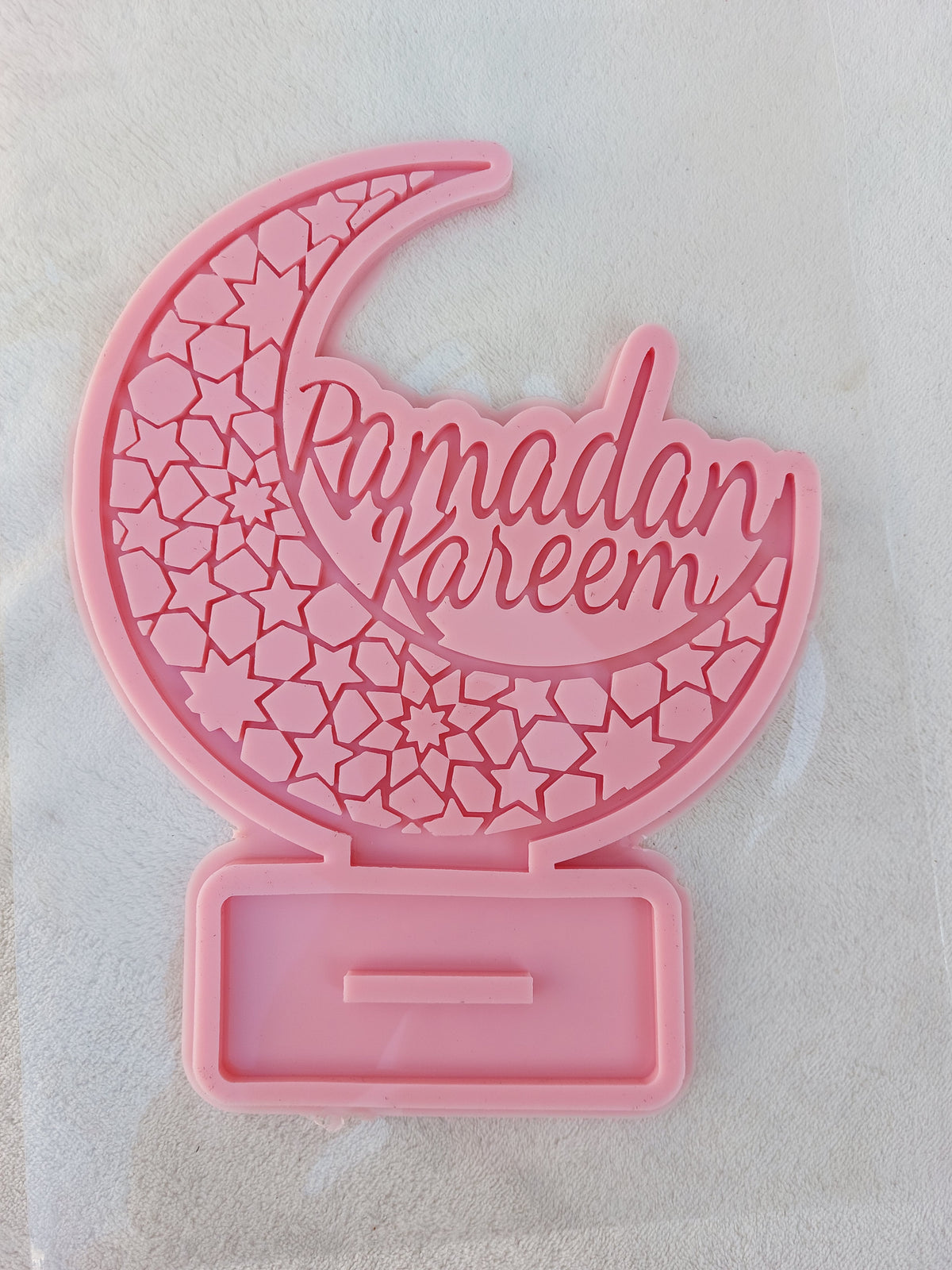 This silicone mold is suitable for casting resin, wax, or ceramics. Inside the circle is the phrase "Ramadan Kareem" in an intricate and beautiful design, clearly depicting domes, minarets, and pointed architectural motifs.