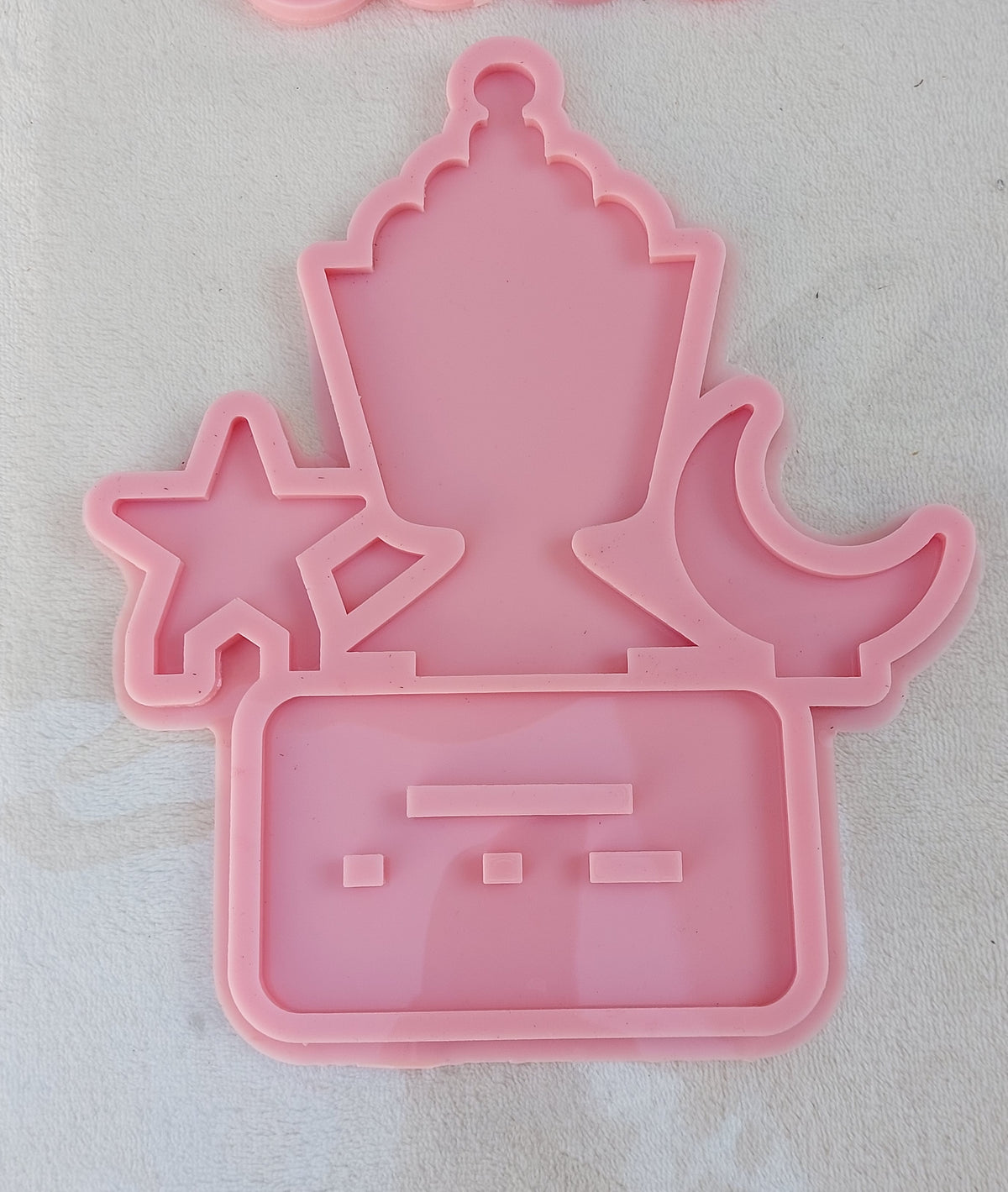 This silicone mold features three separate shapes: a traditional lantern in the center, a five-pointed star on the left, and a crescent moon on the right. It is suitable for casting resin, wax, plaster, or ceramics. size is 15*9 cm
