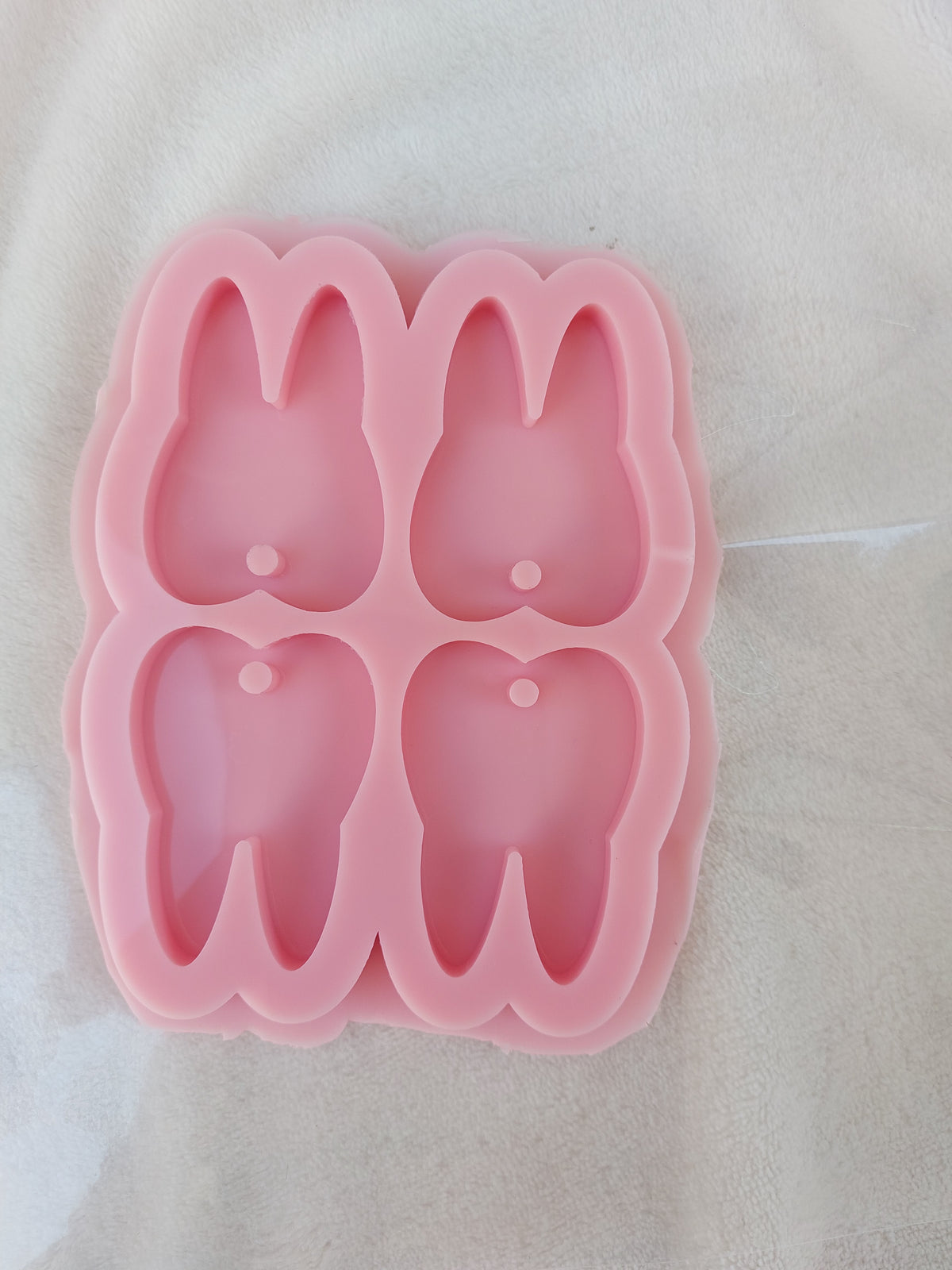 This silicone mold has four cavities and is designed for crafts, resin casting, wax casting, and pottery. It is used in making keychains and pendants.