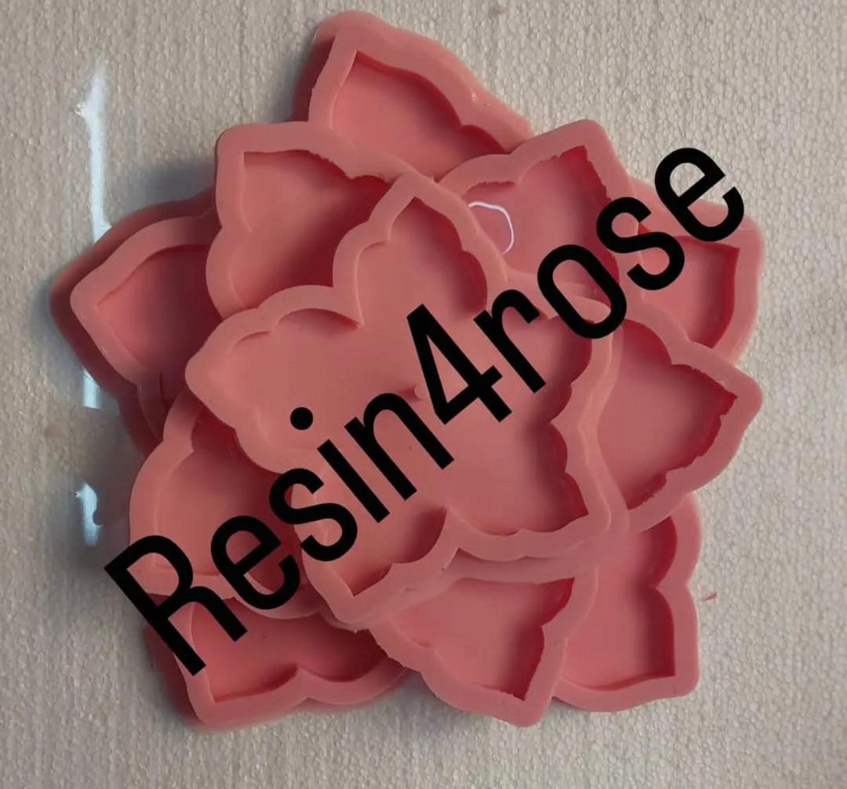 The silicone mold features a design in the shape of a blooming flower with wide, curved petals. The molds appear as a set of several overlapping or stacked molds.