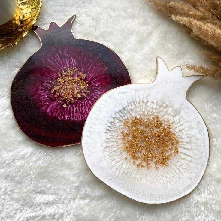 A silicone mold specially designed for crafting projects such as casting resin, polymer clay, wax, or pottery. The mold consists of two connected cavities shaped like a pomegranate, measuring 9 cm in length and 8 mm in depth.