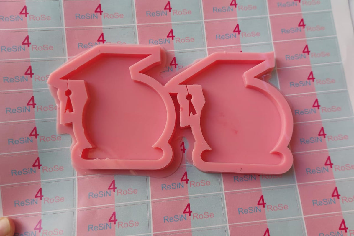 A silicone mold designed for crafts such as resin casting, polymer clay, or wax. The mold has two connected cavities, each designed in the shape of a graduation cap. Size: 8*6 cm