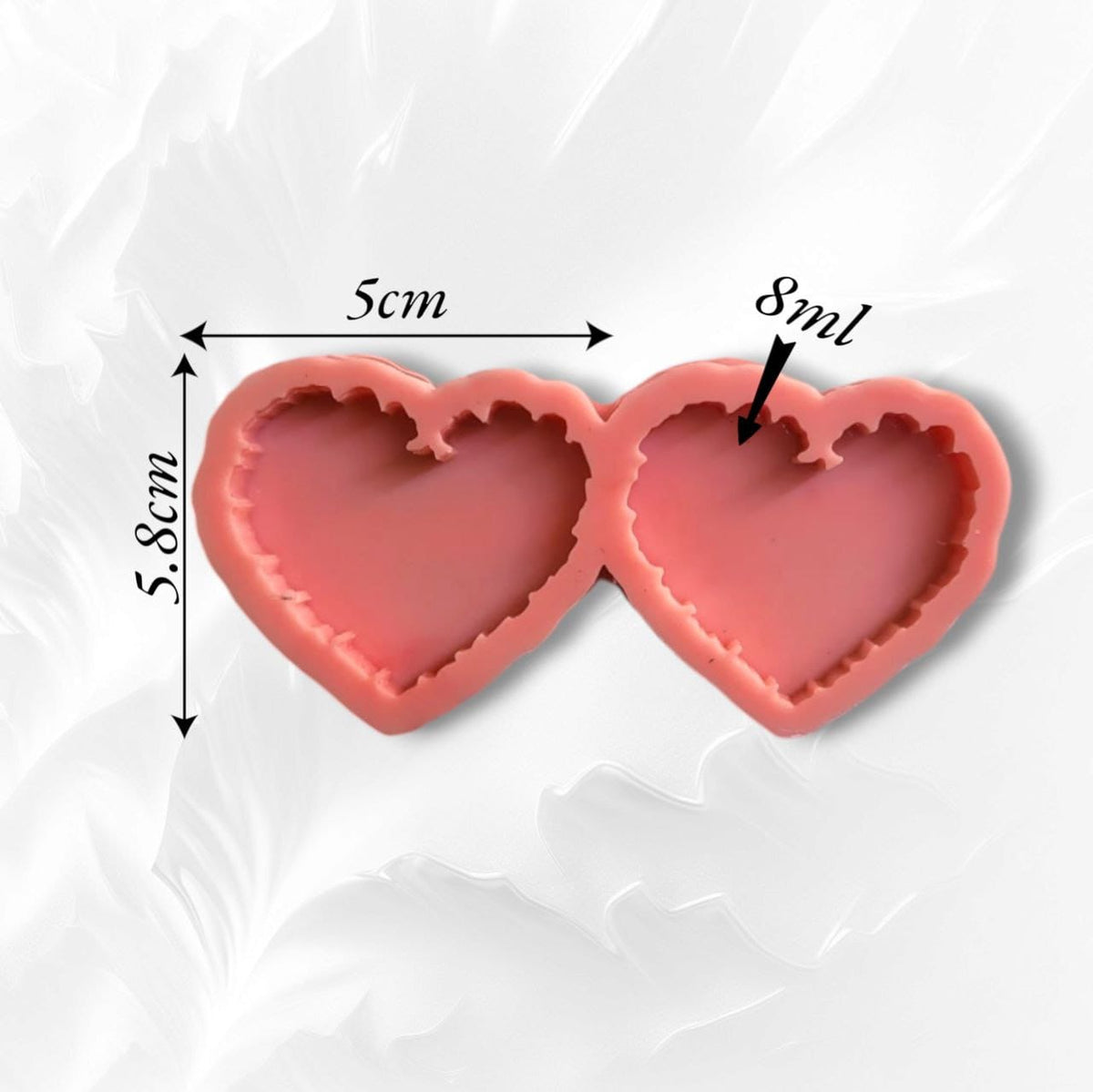 A silicone mold designed to create double heart-shaped pieces with decorative (sounding) inner edges, giving the finished piece an aesthetically pleasing appearance. It can be used for casting resin, ceramics, or wax. Size: 5*5.8 cm