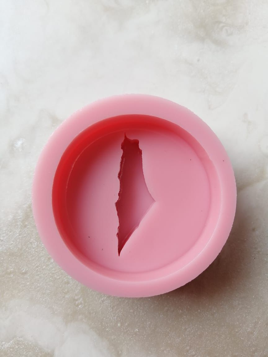 A round silicone mold with a raised Palestinian flag, suitable for making resin, candle, or concrete pendants, as well as scented soaps and fragrant mastic.