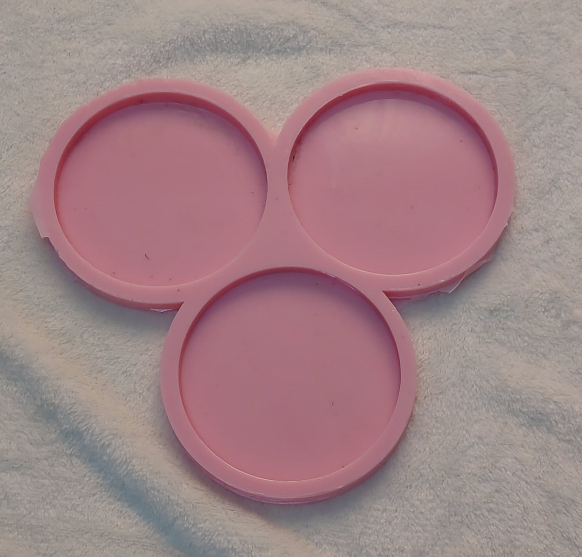 This silicone mold is specially designed for crafting projects such as casting resin, wax, or pottery. The mold consists of three interconnected circular cavities, each with a diameter of 9 cm and a depth of 8 mm.