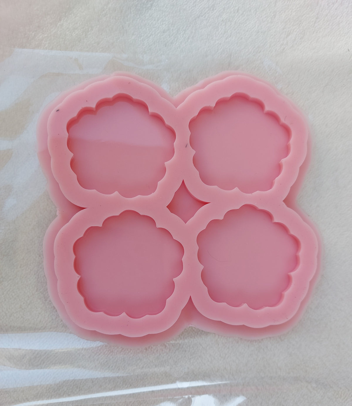 This silicone mold is specially designed for craft projects such as resin, wax, or pottery casting. The mold consists of four interconnected cavities, resembling flower petals, and is available in 2 different sizes.