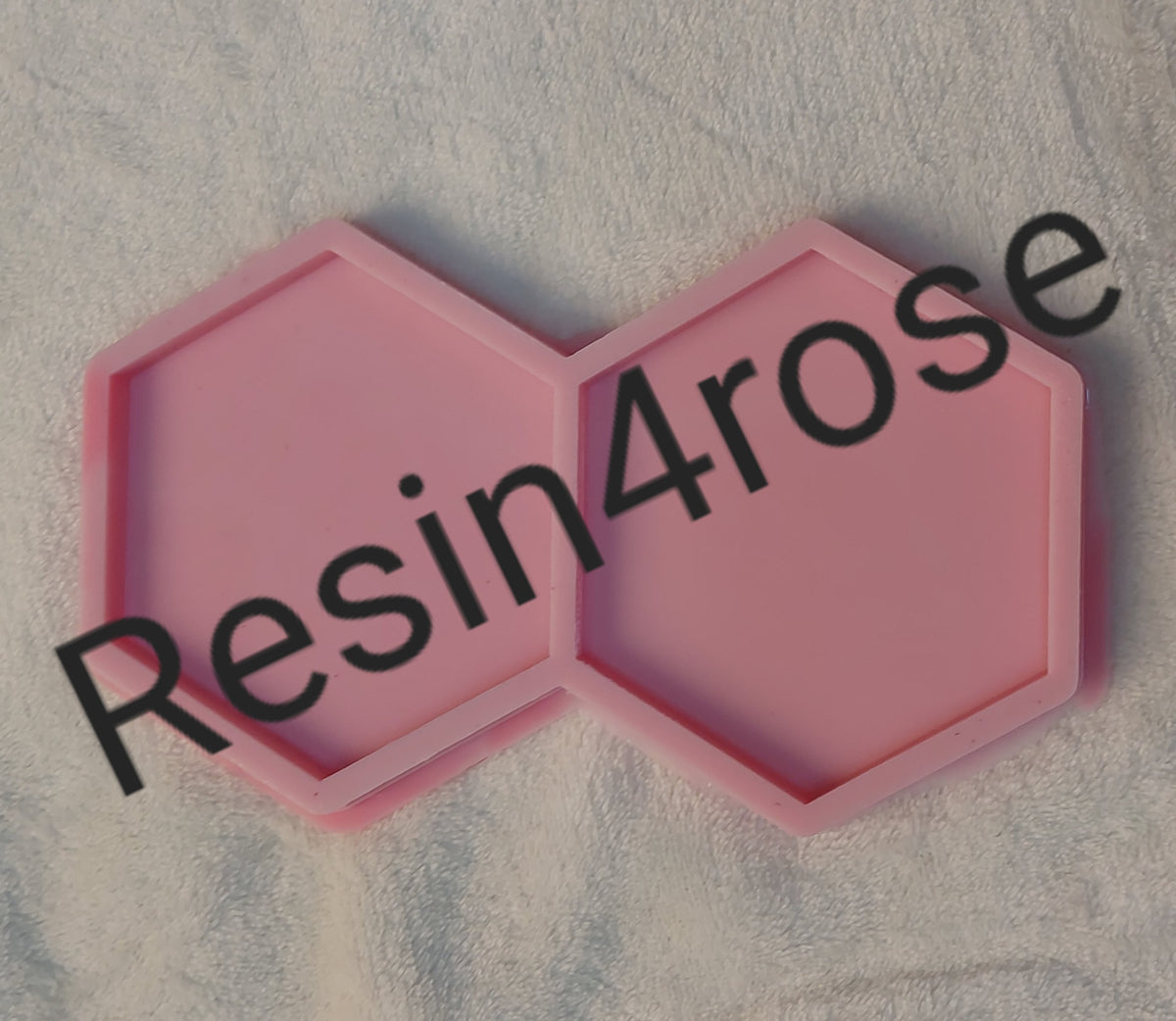 A silicone mold featuring a geometric shape consisting of two hexagonal cavities, available in two different sizes.
