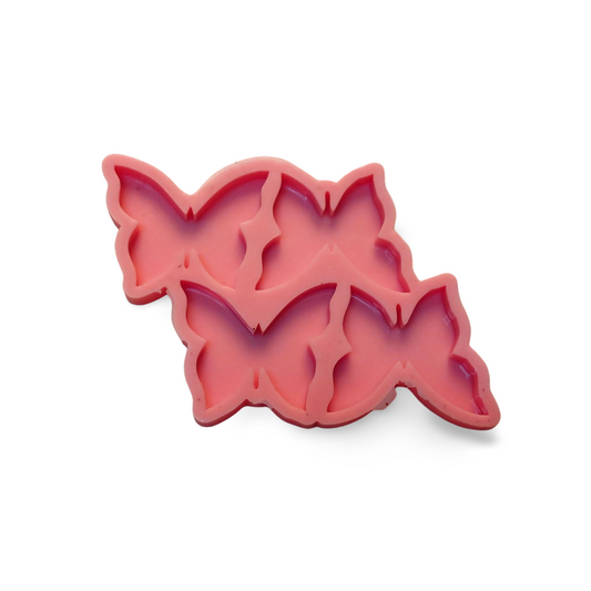 A silicone mold featuring a design that combines four butterflies into a single artistic composition, suitable for making resin, wax, or ceramic medallions. Size 5