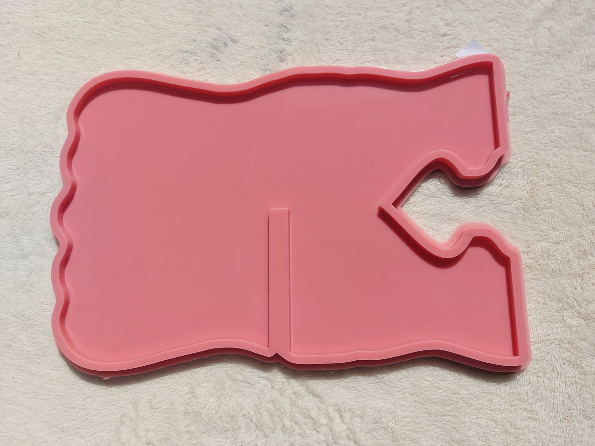 A silicone mold in the shape of a Quran stand designed for casting resin, wax, or pottery. The design features wavy, irregular outer edges, giving the finished piece a modern and attractive look when cast with resin. Available in two different sizes