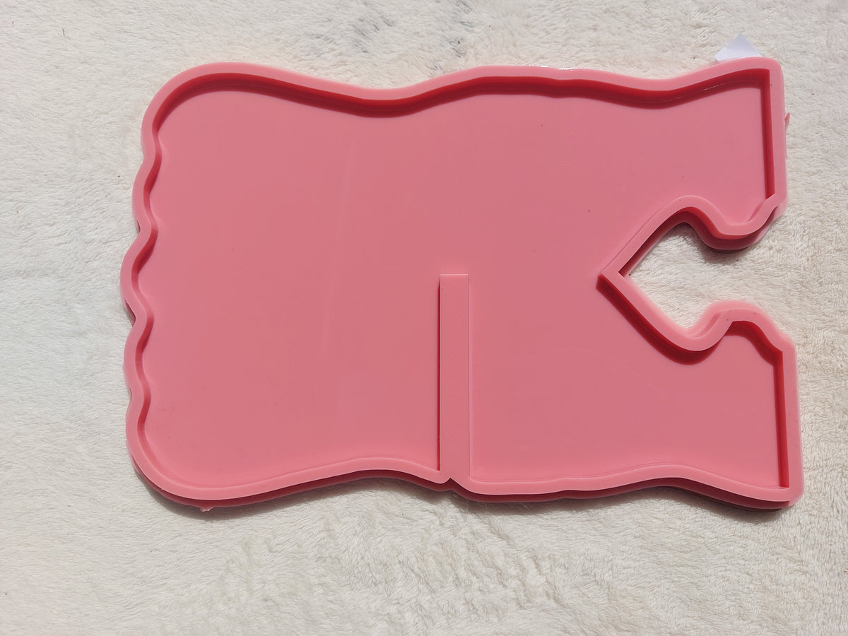 A silicone mold in the shape of a Quran stand designed for casting resin, wax, or pottery. The design features wavy, irregular outer edges, giving the finished piece a modern and attractive look when cast with resin. Available in two different sizes