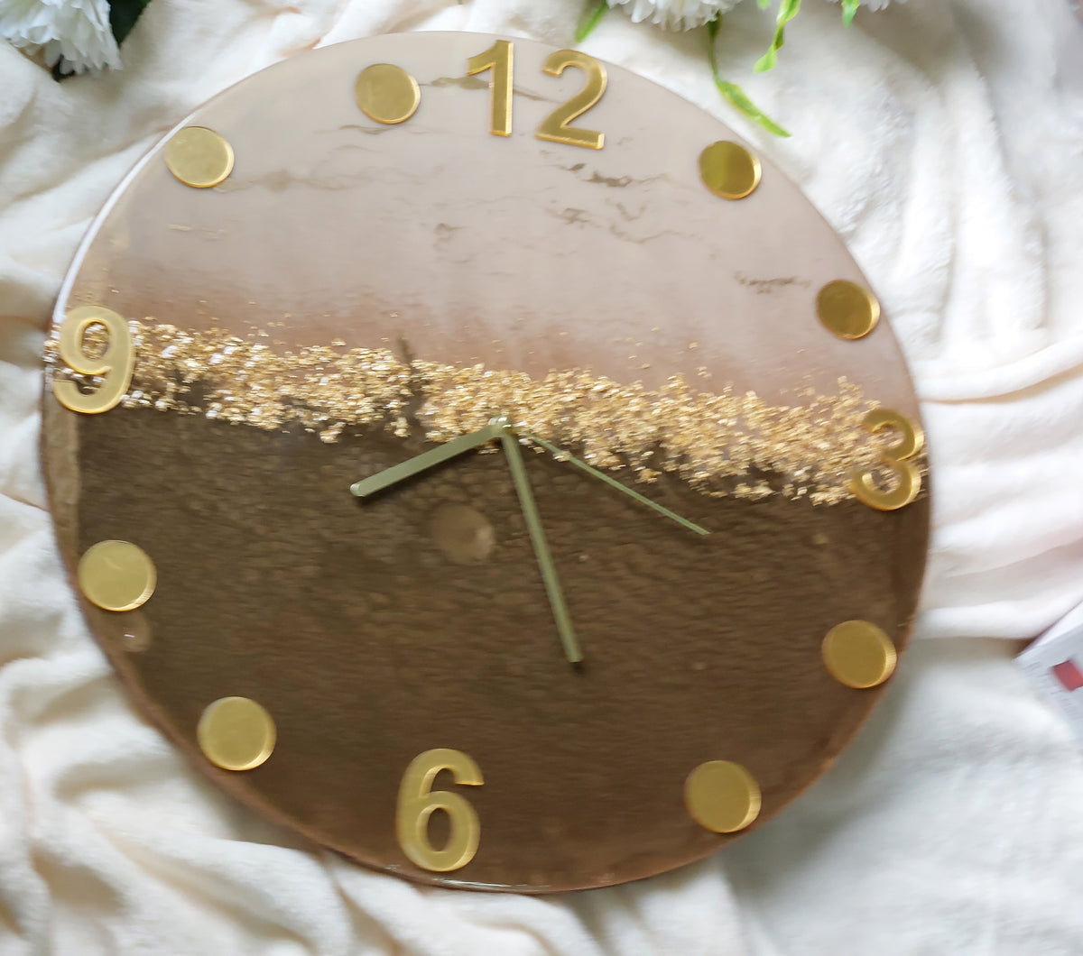 A clever and elegant design combines numerals and circular hour markers made of mirrored acrylic in a lustrous gold or silver finish.  Only the key numerals are positioned at the 12, 3, 6, and 9 o'clock positions to clearly indicate the time
