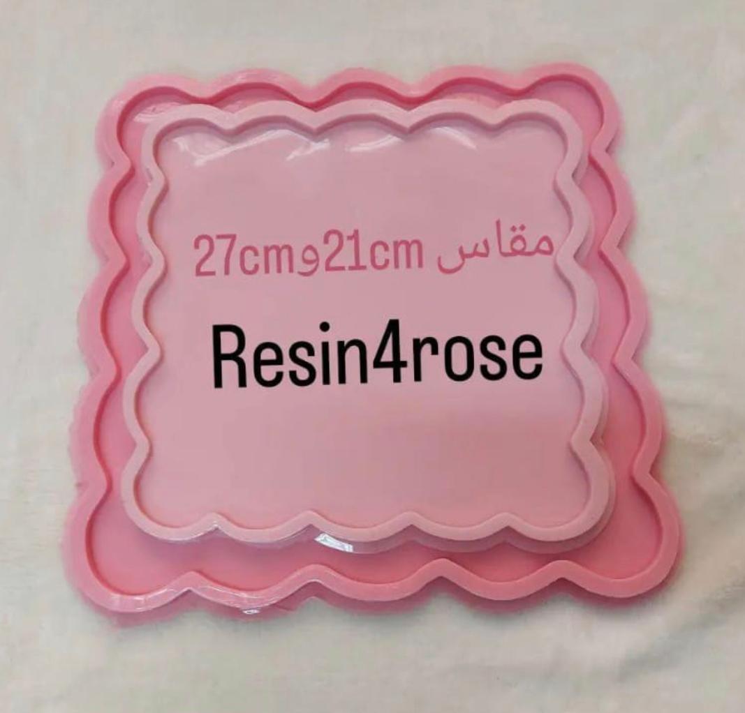 This silicone mold features a square design with aesthetically pleasing and regular wavy edges. The mold is designed with a multi-layer system, and the image shows it as a set of two sizes: 21 cm and 27 cm.
