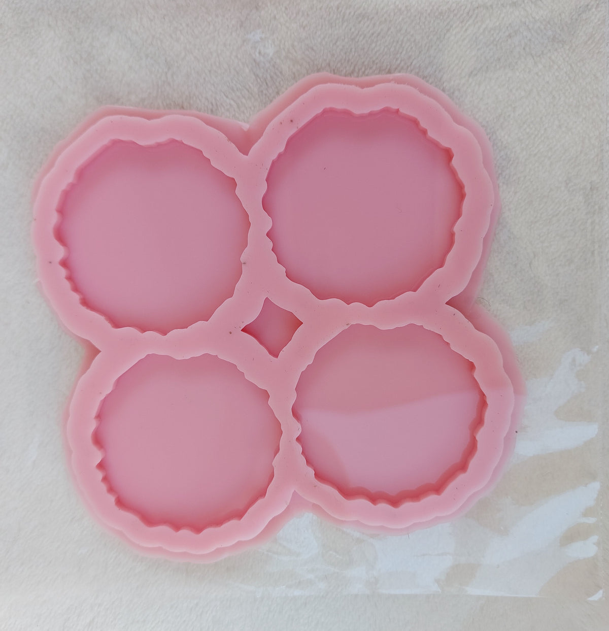 This silicone mold is specially designed for craft projects such as resin, wax, or pottery casting. The mold consists of four interconnected cavities, resembling flower petals, and is available in four different sizes.