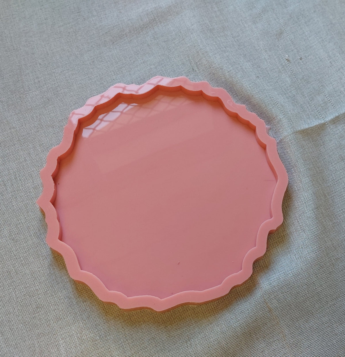 A round silicone mold with irregular, wavy edges, designed for artistic casting work such as resin, pottery, or plaster. Available in various sizes.