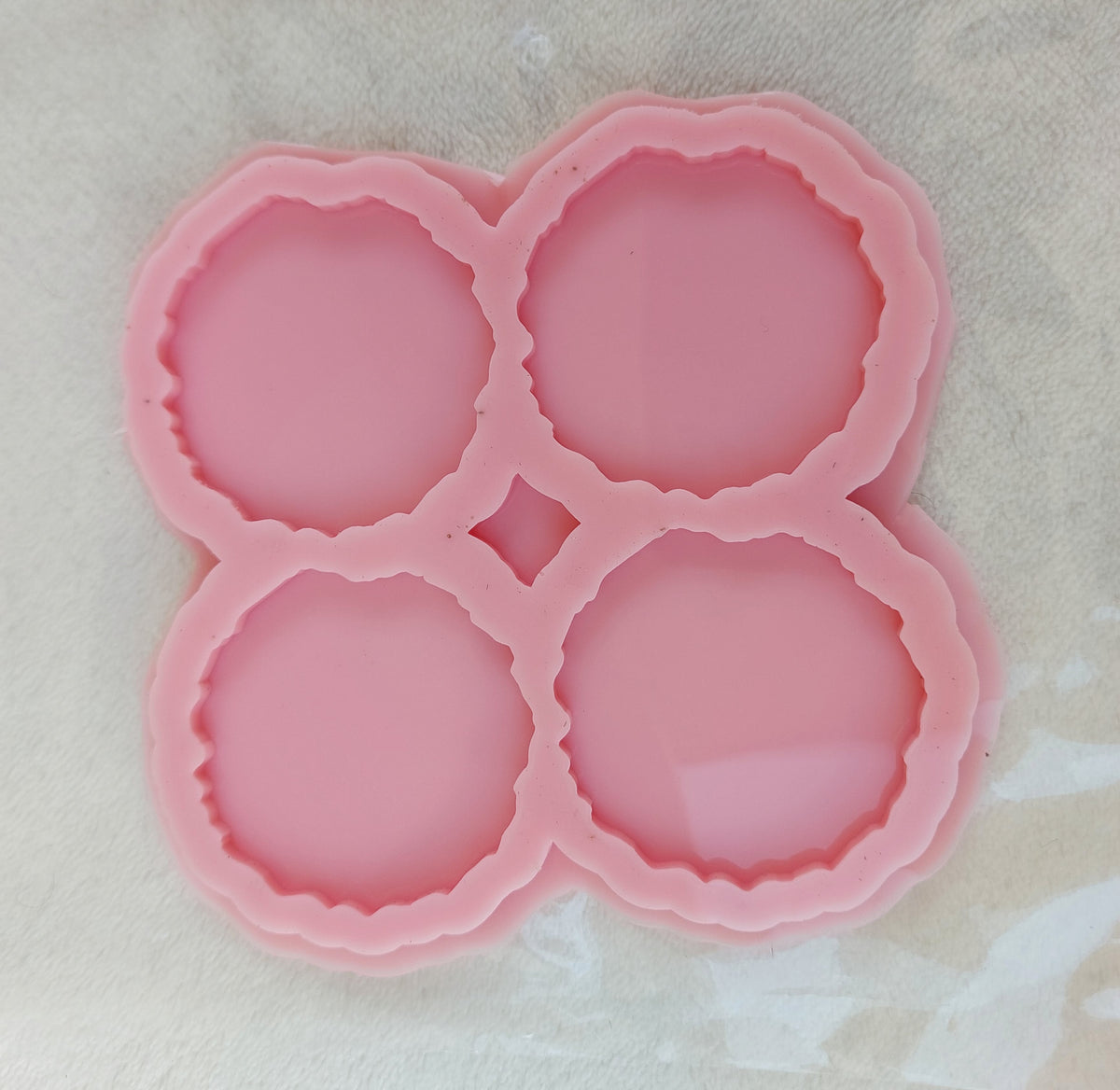 This silicone mold is specially designed for craft projects such as resin, wax, or pottery casting. The mold consists of four interconnected cavities, resembling flower petals, and is available in four different sizes.