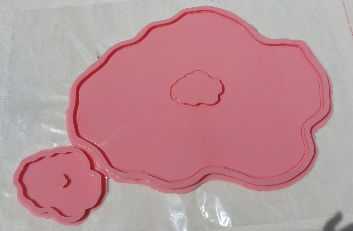 This silicone mold features an irregular, organic design that mimics the wavy edges of natural gemstones or stone slabs. It has a wide, flat main cavity with a small, irregularly shaped protrusion in the center.