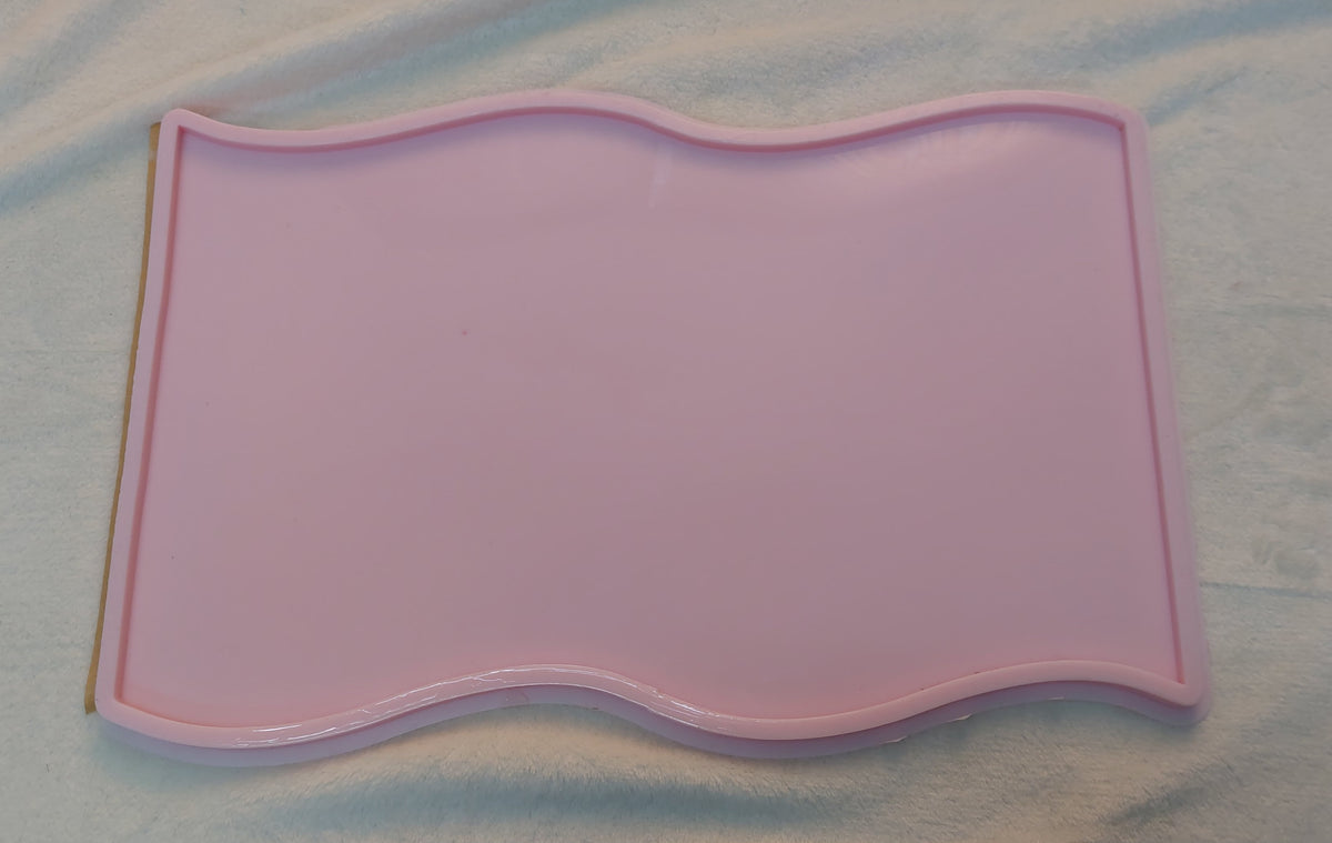 A sleek, rectangular silicone mold with an artistic touch, featuring wavy, wave-like edges on the top and bottom.  Size 42