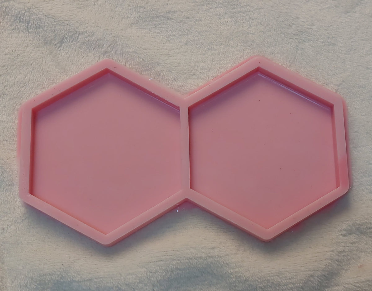 A silicone mold featuring a geometric shape consisting of two hexagonal cavities, available in two different sizes.