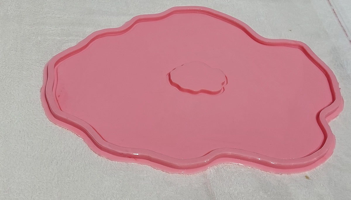 This silicone mold features an irregular, organic design that mimics the wavy edges of natural gemstones or stone slabs. It has a wide, flat main cavity with a small, irregularly shaped protrusion in the center.