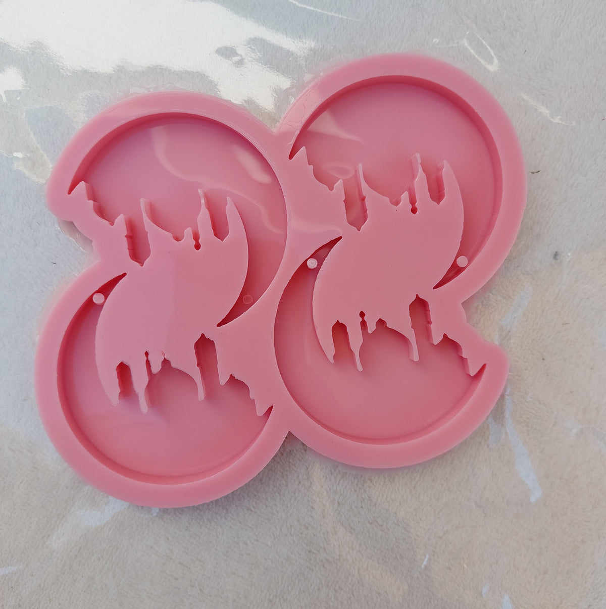 A silicone mold containing a Ramadan crescent with a mosque inside. This mold is a unique addition due to the complexity of its geometric patterns and its integrated design. It is suitable for casting resin, wax, plaster, or pottery