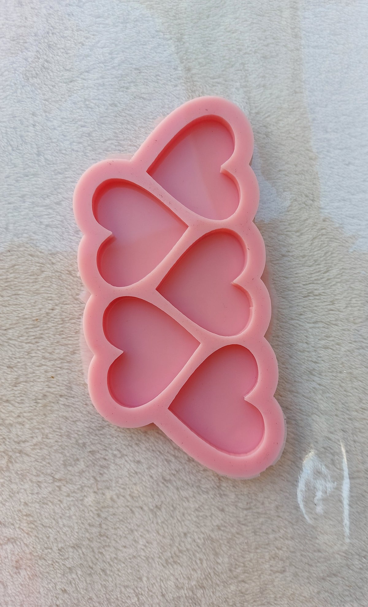 This silicone mold features five interconnected, vertically overlapping heart-shaped cavities, giving it a smooth, wavy exterior ideal for resin, plaster, or pottery enthusiasts to create small decorative pieces, souvenirs, or miniature medals