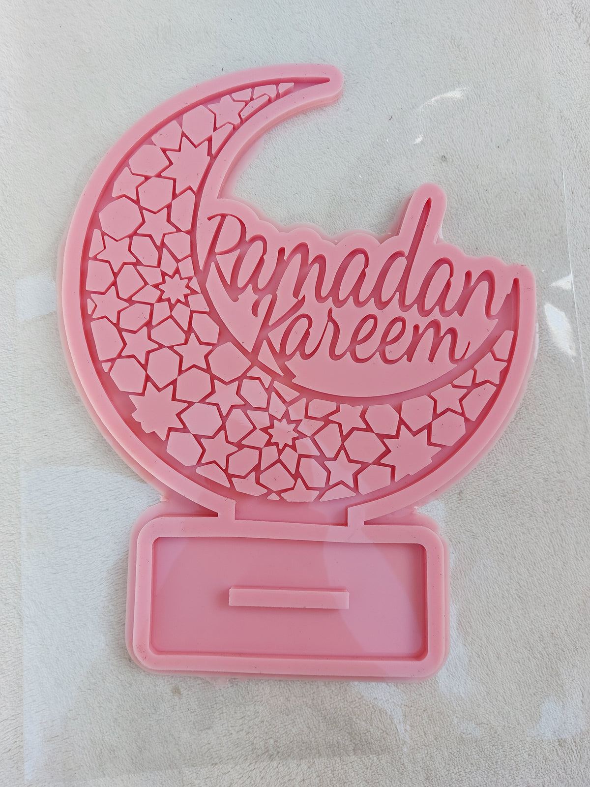 This silicone mold is suitable for casting resin, wax, or ceramics. Inside the circle is the phrase "Ramadan Kareem" in an intricate and beautiful design, clearly depicting domes, minarets, and pointed architectural motifs.