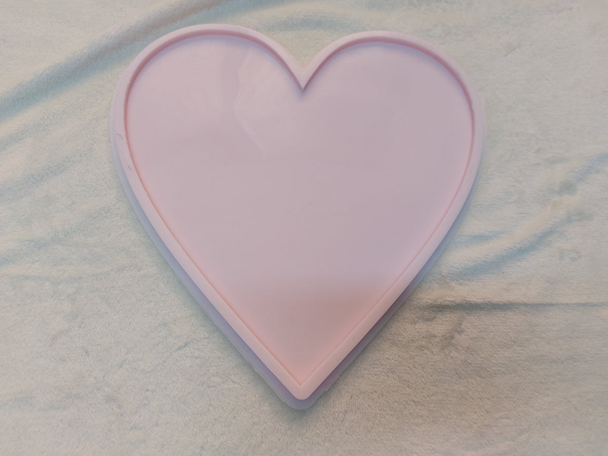 This silicone mold takes the shape of a perfectly symmetrical heart, with smooth top curves and a pointed bottom. It features a simple and practical design ideal for craft projects such as casting resin, plaster, or pottery.