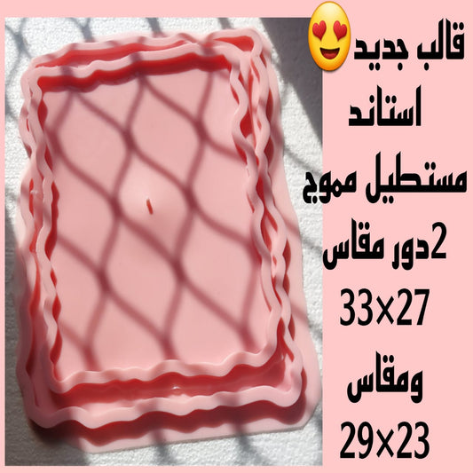This silicone mold features a rectangular shape with aesthetically pleasing and regular wavy edges. It has an inner casting area and a slightly larger outer one, both bearing the same wavy pattern. It is available in two different sizes.