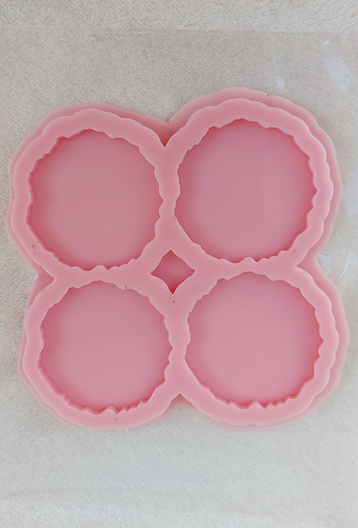 This silicone mold is specially designed for craft projects such as resin, wax, or pottery casting. The mold consists of four interconnected cavities, resembling flower petals, and is available in four different sizes.