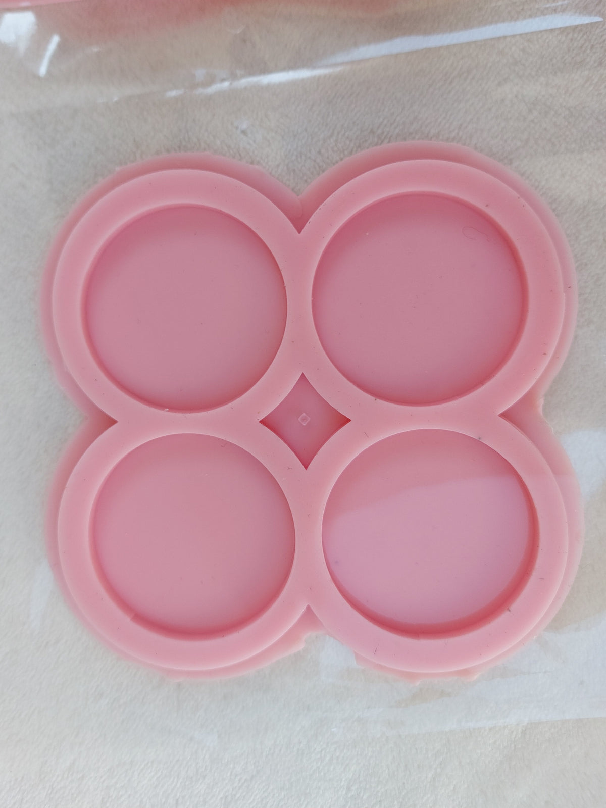 This silicone mold is specially designed for craft projects such as resin, wax, or pottery casting. The mold consists of four interconnected cavities, resembling flower petals, and is available in 3 different sizes.