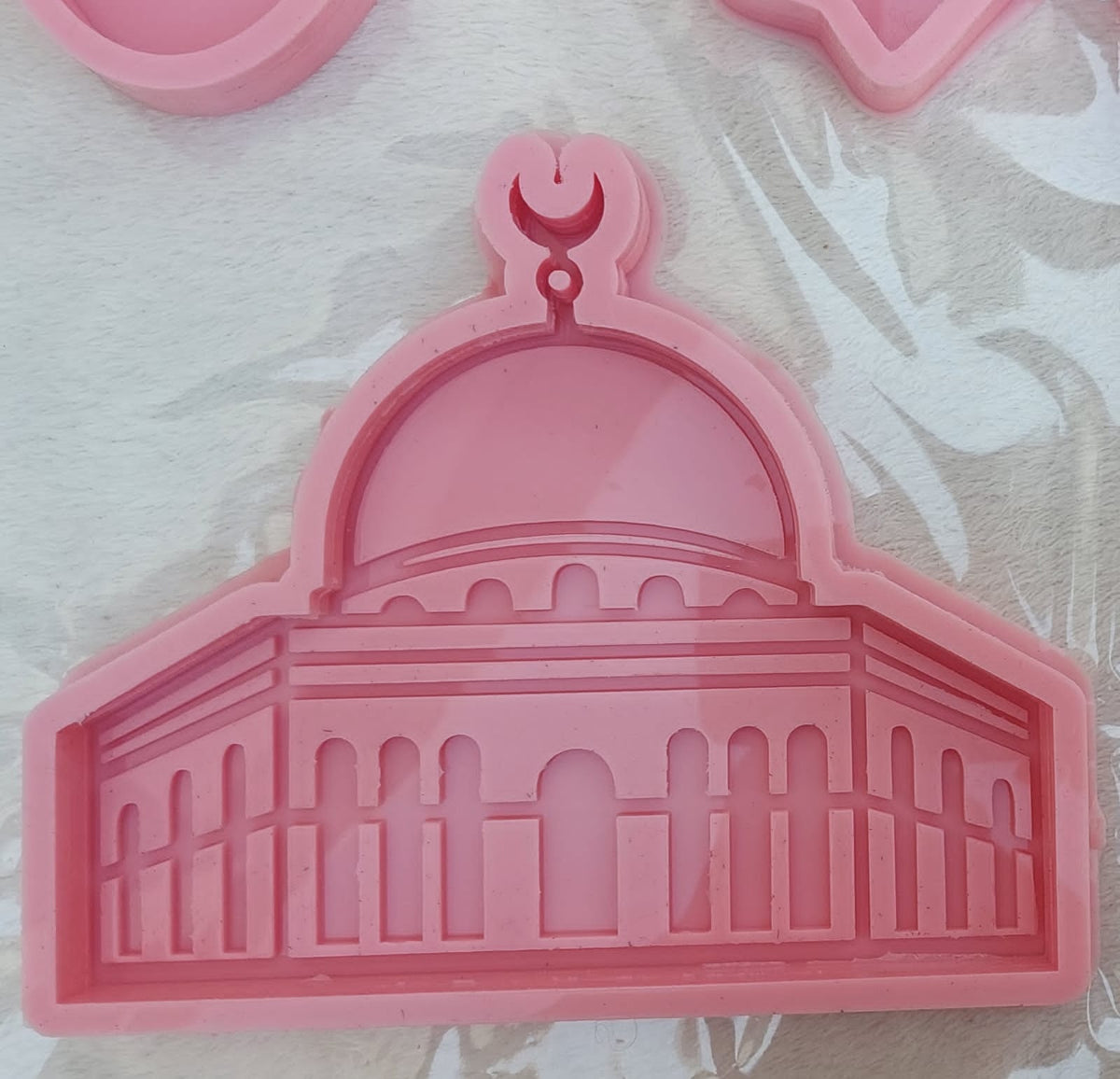 A silicone mold designed in the shape of the Dome of the Rock mosque, suitable for casting resin, wax, or ceramic. The design features intricate details of the arches and vertical lines that represent the octagonal facade of the mosque