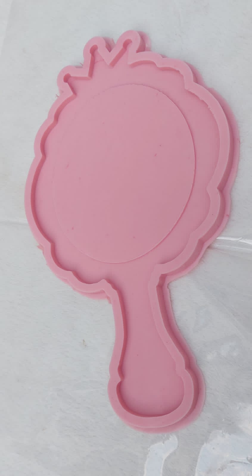 This silicone mold is designed in the shape of a classic hand mirror. The top features a decorative wavy edge and crown-like details at the apex, making it ideal for creating luxurious personalized gifts or unique decorative pieces for a vanity.