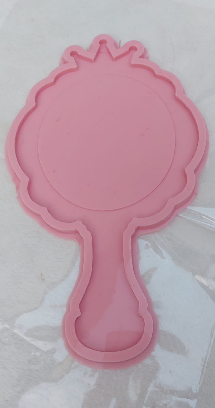 This silicone mold is designed in the shape of a classic hand mirror. The top features a decorative wavy edge and crown-like details at the apex, making it ideal for creating luxurious personalized gifts or unique decorative pieces for a vanity.