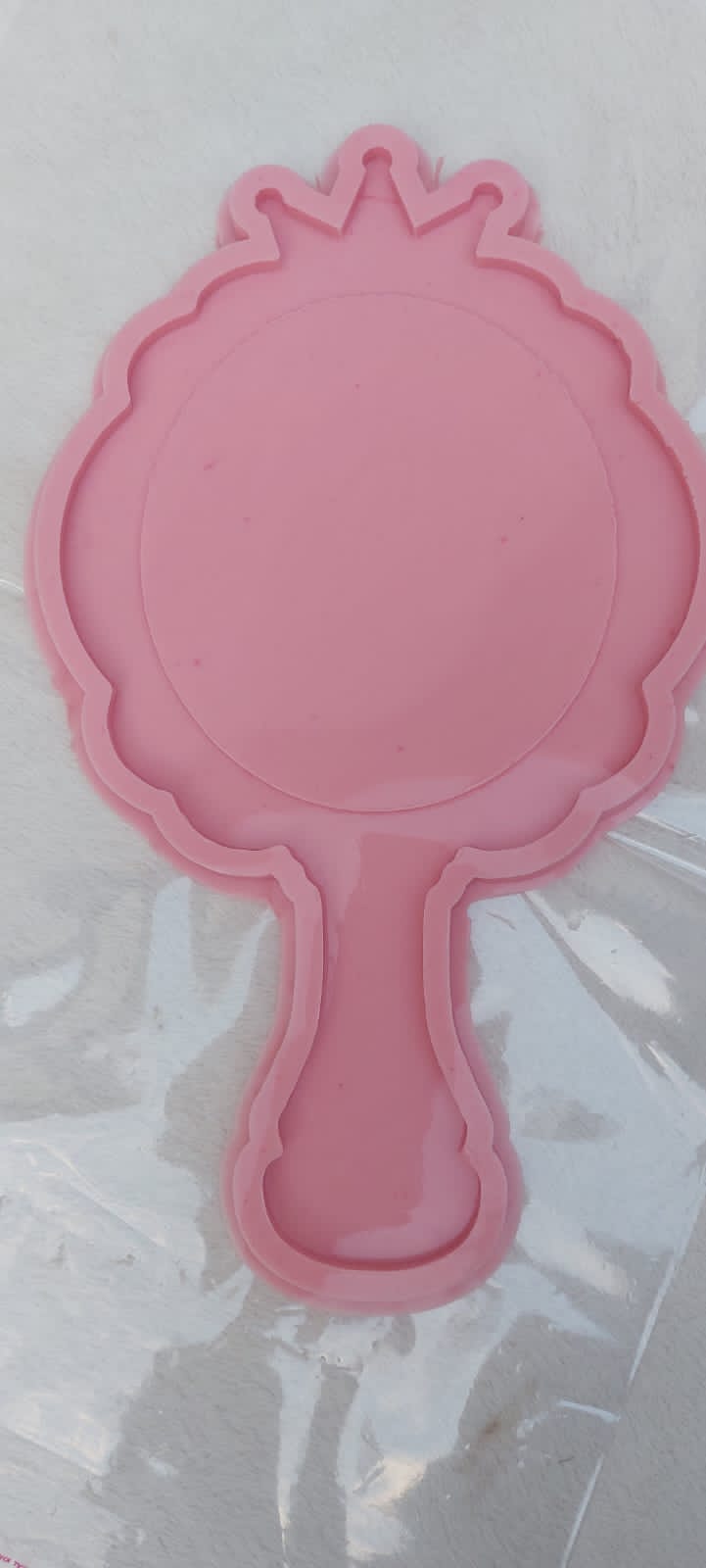 This silicone mold is designed in the shape of a classic hand mirror. The top features a decorative wavy edge and crown-like details at the apex, making it ideal for creating luxurious personalized gifts or unique decorative pieces for a vanity.