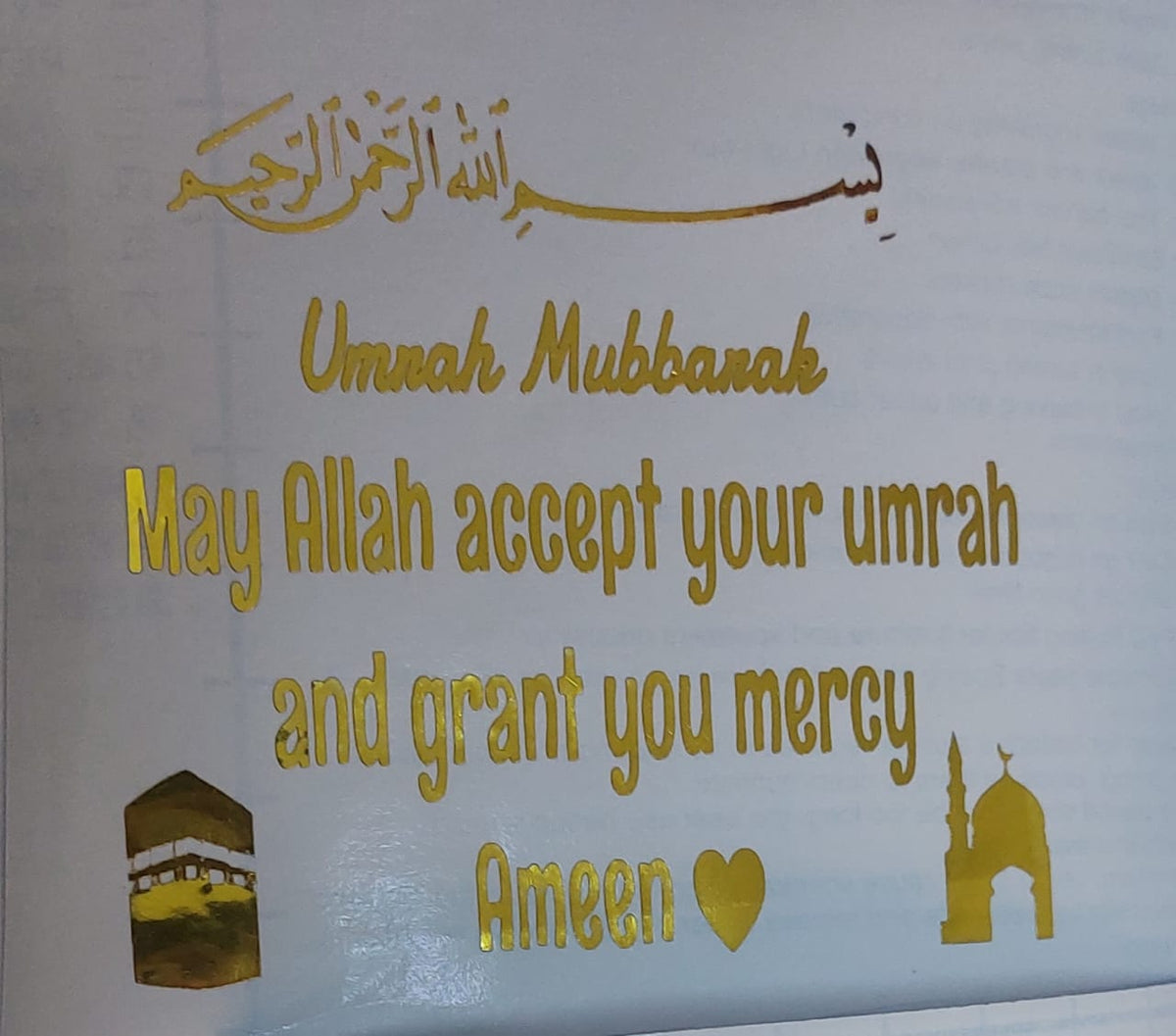 A ready-to-transfer vinyl sticker designed to celebrate a special religious occasion, which is performing the Umrah rituals, and designed in a shiny gold color to offer congratulations and prayers