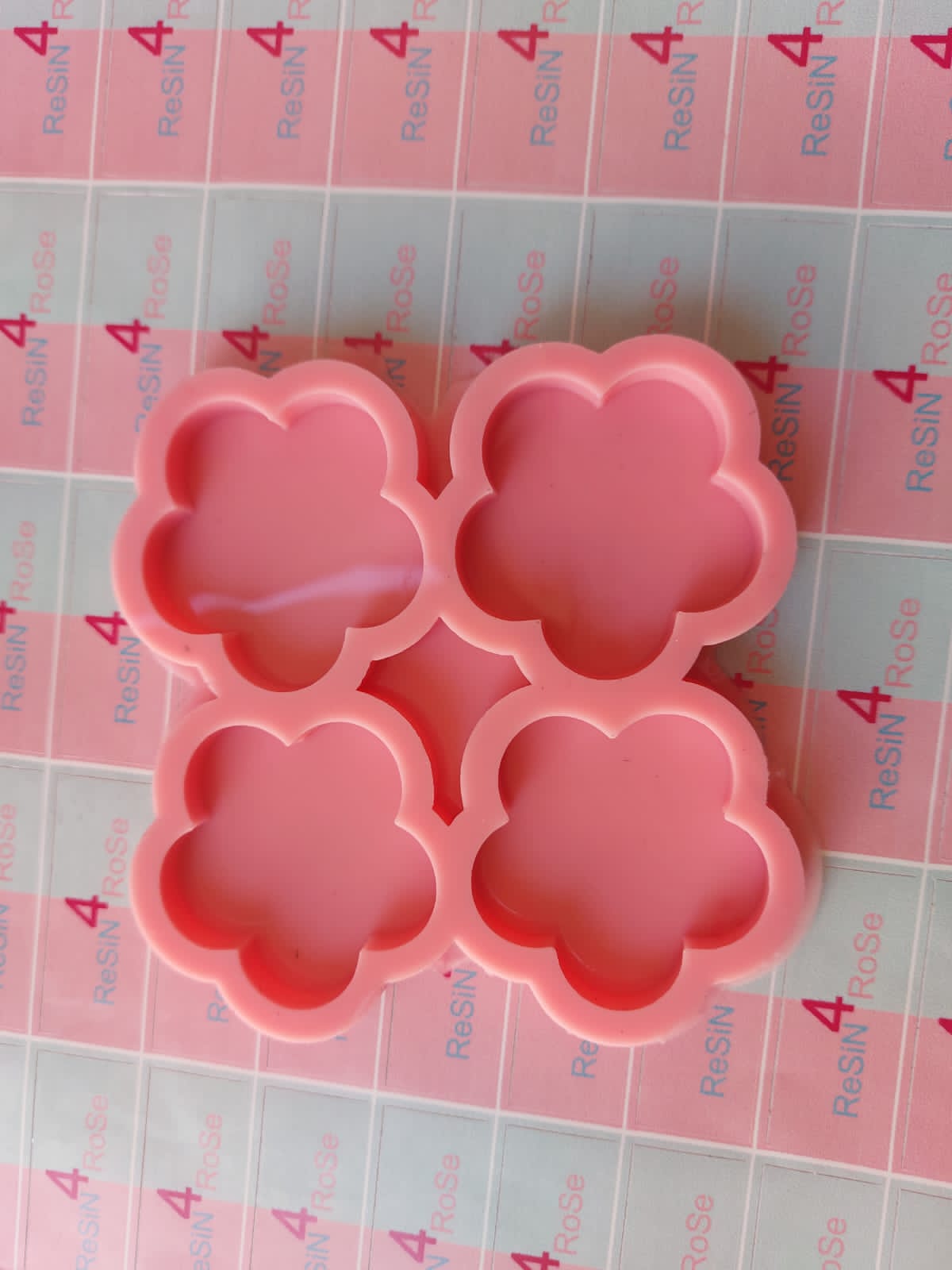 A silicone mold designed for crafts such as casting resin, polymer clay, or wax. It features four interconnected cavities, each designed in the shape of a five-petaled rose with smooth, rounded edges. Size: 5 cm