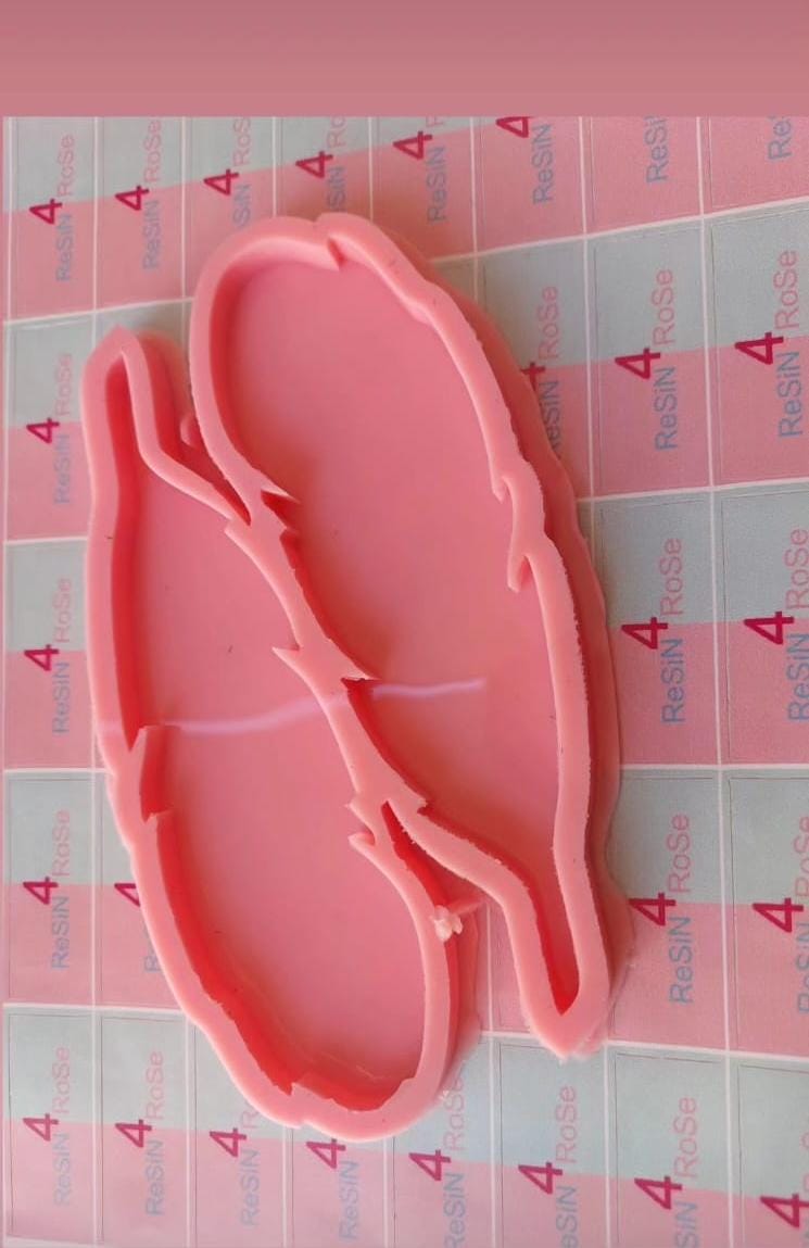 A silicone mold containing two partially connected cavities, each designed in the shape of a delicate feather with wavy edges that mimic the details of natural feathers, measuring 16.5*5 cm.