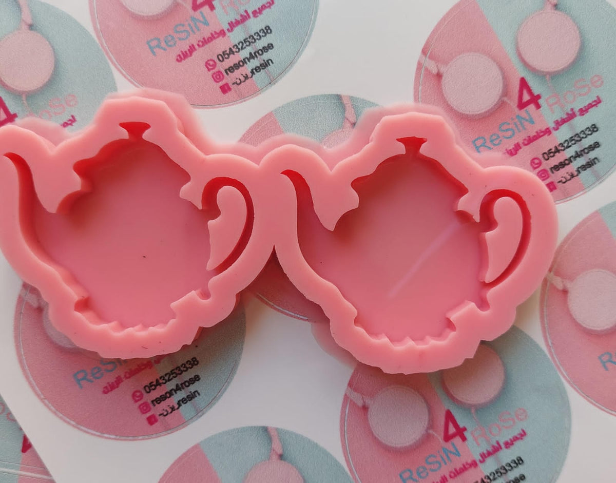 This silicone mold has two interconnected cavities, each designed in the shape of a teapot. This mold allows you to produce multiple identical pieces simultaneously with a small amount of material. Dimensions: 5 x 6 cm, Depth: 8 mm