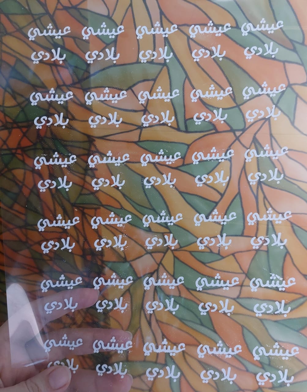 Vinyl, sticker printing, or transparent paper containing printed words in black and a simplified, modern Arabic script, suitable for crafts or resin