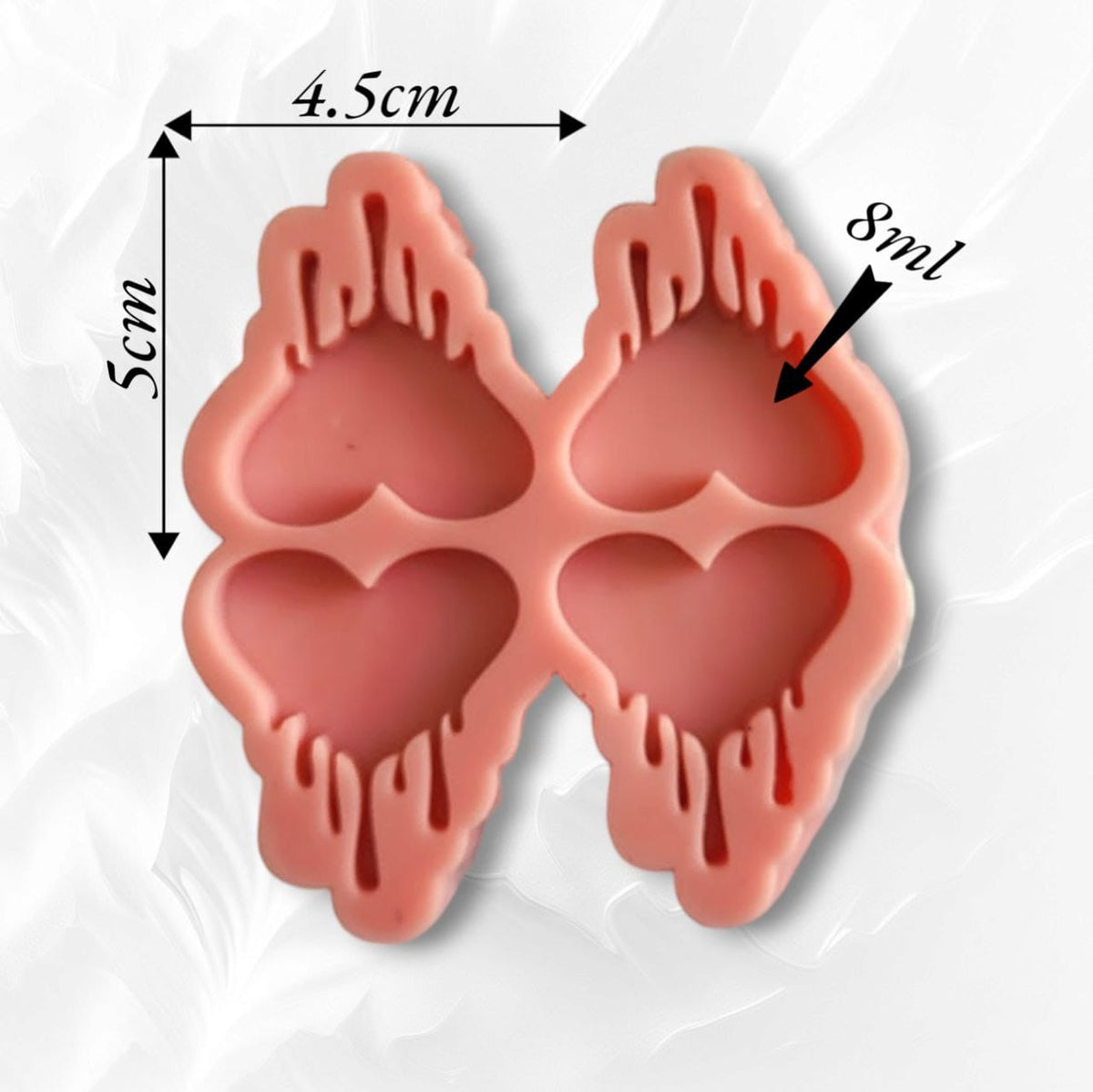 A silicone mold containing four heart-shaped cavities with melting or dripping lines emerging from its upper and lower edges. The design is modern and unconventional, making it a great choice for those who love to stand out in handicrafts