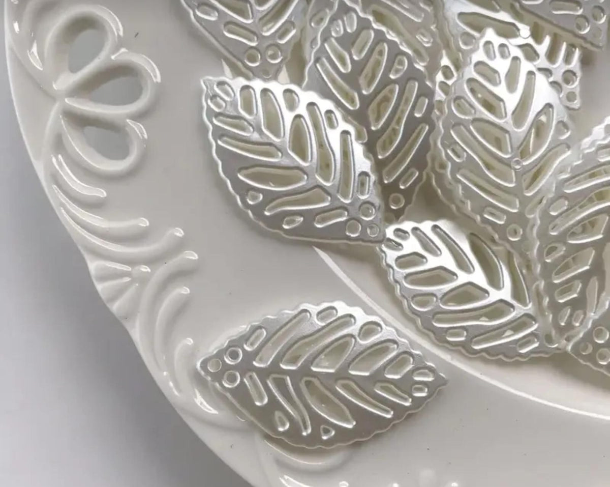These hollow, leaf-shaped pearl fillers and embellishments are very delicate and popular in crafts. They are used inside clear resin molds or glued onto the surfaces of incense burners, trays, and jewelry boxes to give them an elegant and subtle touch