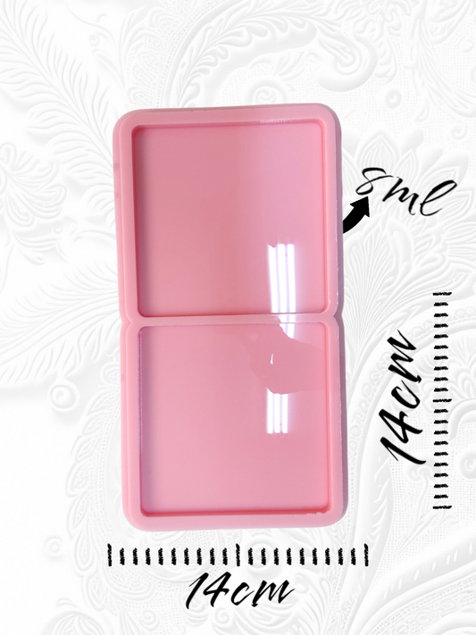 This silicone mold features a rectangular shape divided into two square cavities, ideal for creating two identical pieces simultaneously. Specifically designed for resin, wax, or pottery projects, the mold measures 14 cm in length and width.