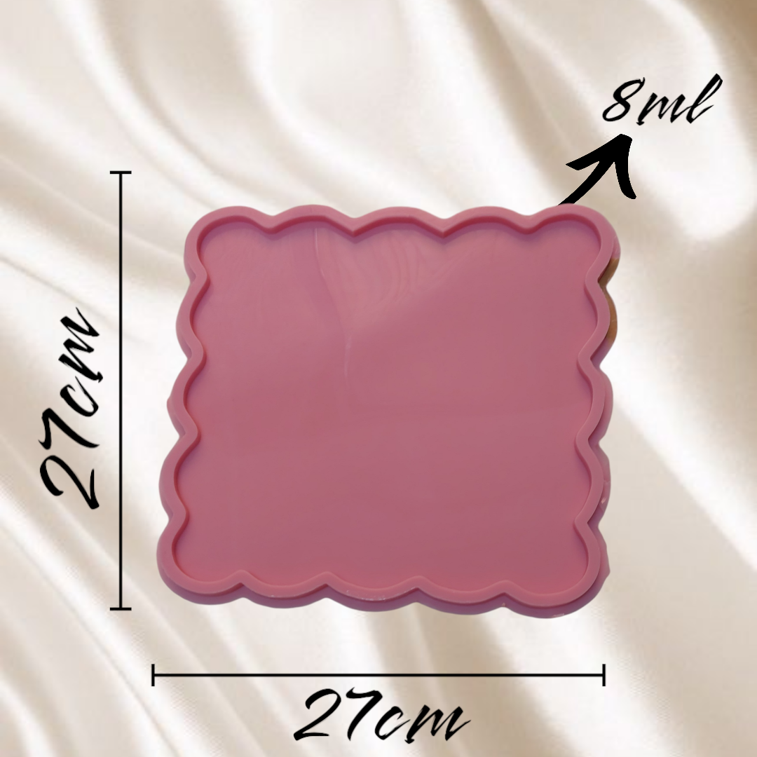 A square-shaped silicone mold with regular wavy edges, consisting of a flat inner cavity surrounded by a raised frame to define the shape and thickness of the piece. Dimensions: 27 x 27 cm, Depth: 8 mm