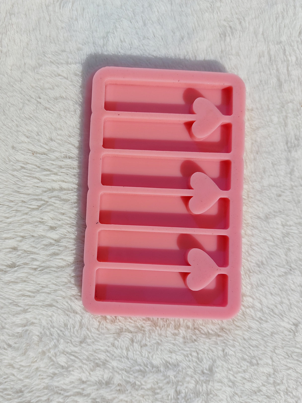A rectangular silicone mold with multiple, organized cavities and a heart-shaped opening connecting each pair of adjacent rectangles, designed for casting resin, wax, or plaster. Dimensions: 3.3 x 6 cm.