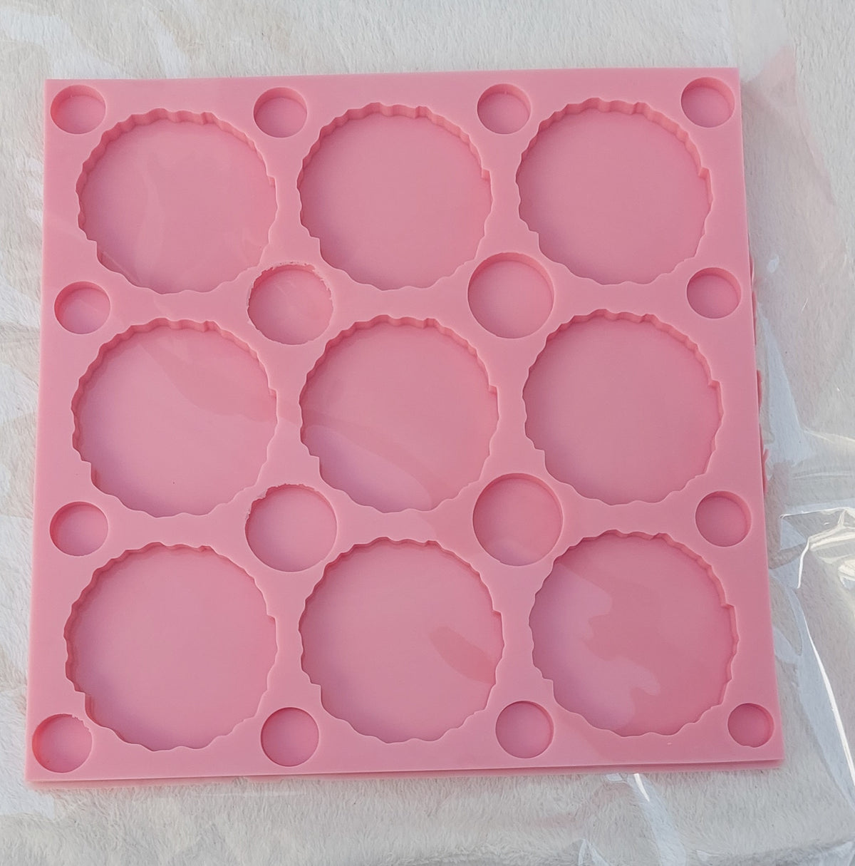 The silicone mold features a large square shape containing several cavities of different sizes.
