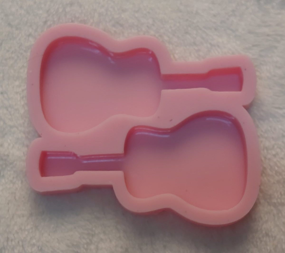 This silicone mold is suitable for casting resin, wax, or ceramic. Each cavity is designed in the shape of a guitar. This mold is perfect for making keychains, earrings for music lovers, or small decorative items for phones and bags.