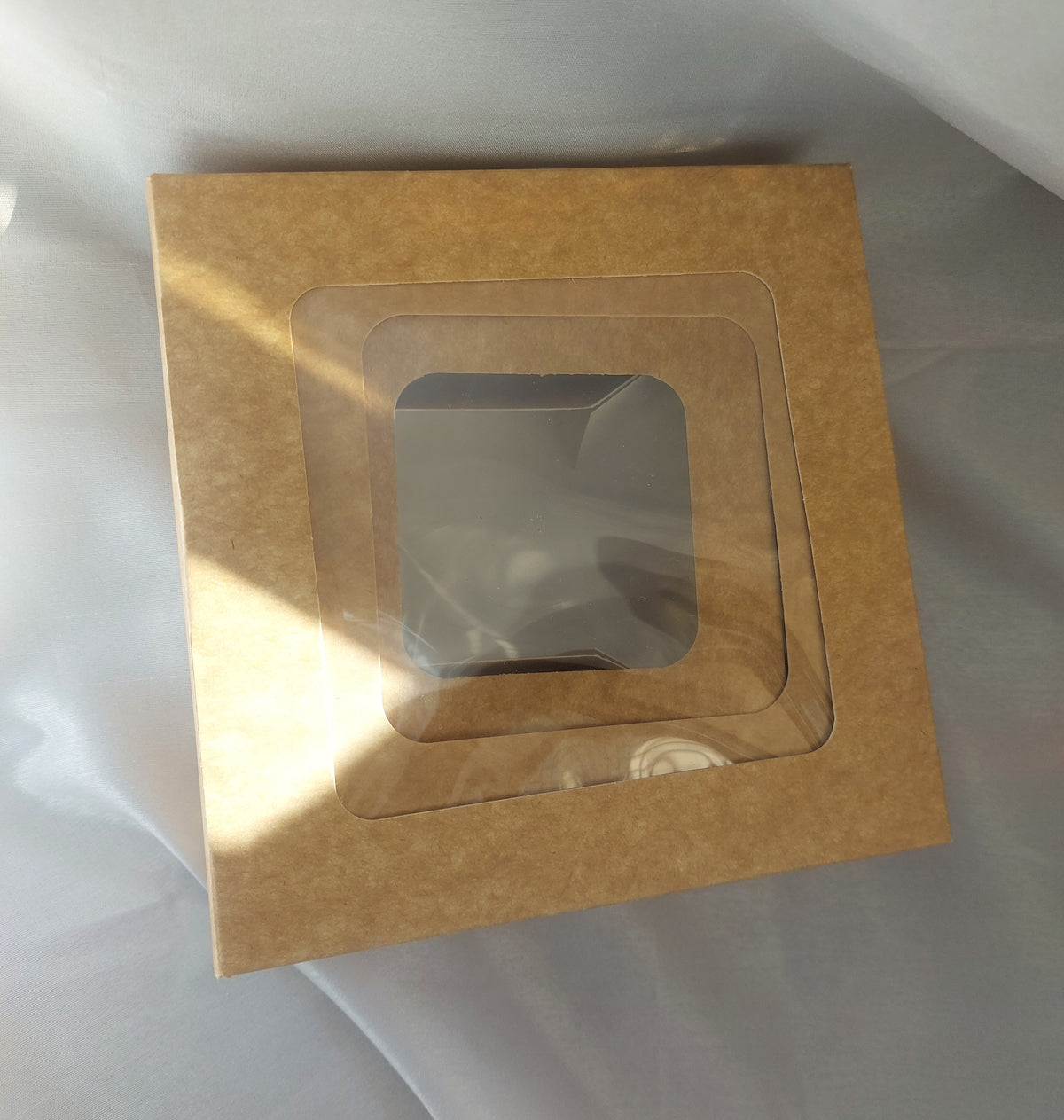 A luxurious and practical collection of packaging boxes made from natural kraft paper, featuring a transparent rectangular window that allows the products inside to be clearly and attractively displayed without the need to open the box