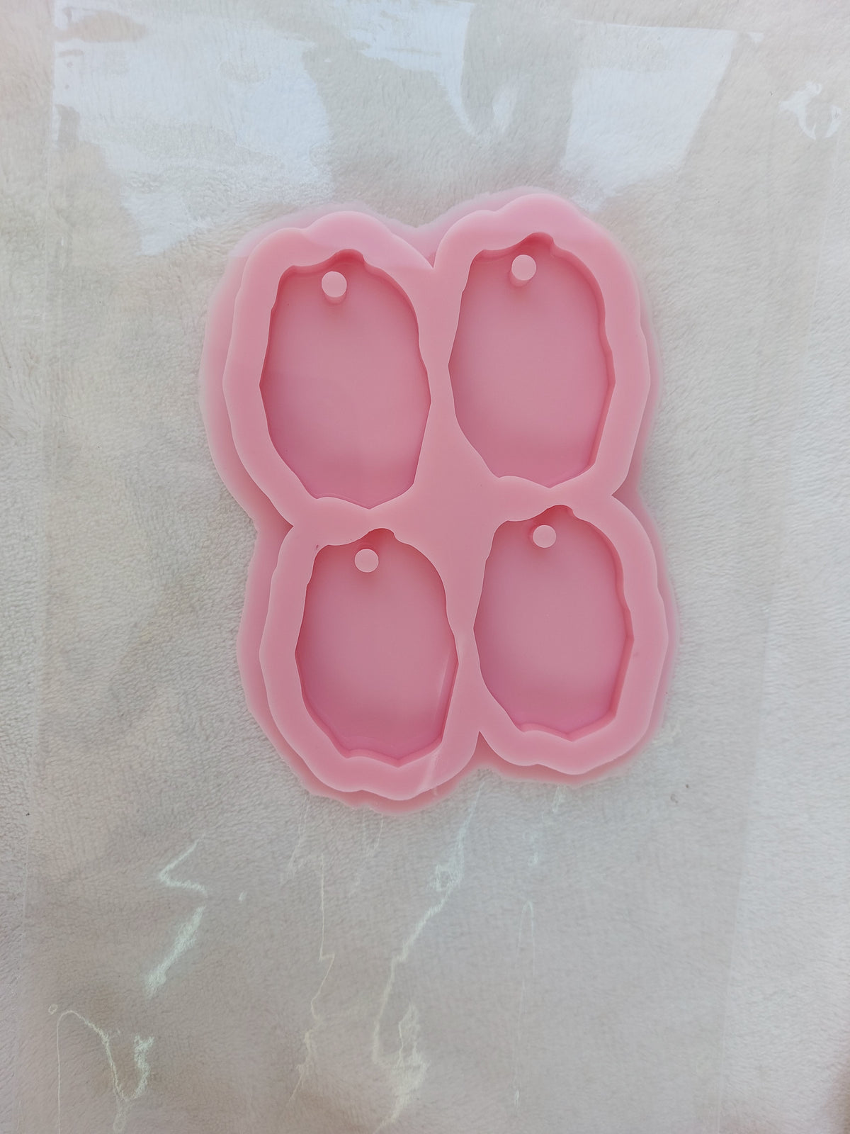 This silicone mold has four cavities and is designed for crafts, resin casting, wax casting, and pottery. It is used in making keychains and pendants. size 6*4cm