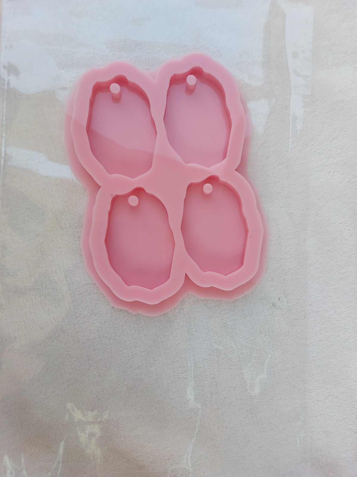 This silicone mold has four cavities and is designed for crafts, resin casting, wax casting, and pottery. It is used in making keychains and pendants. size 6*4cm