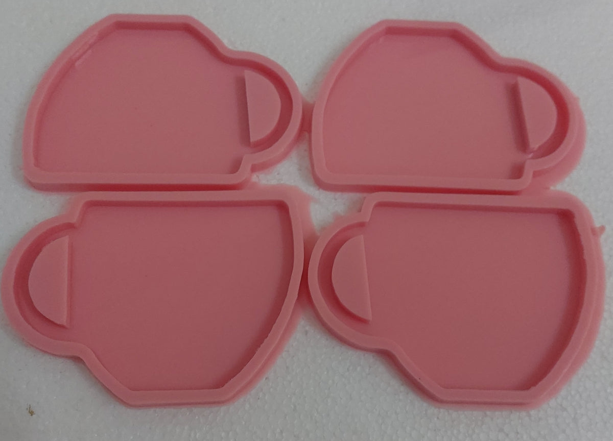 The silicone mold has 4 identical cavities, arranged in two rows. The mold is designed to cast four pieces at once, as it contains 4 interconnected cavities, each cavity taking the shape of a cup or coffee/tea mug.